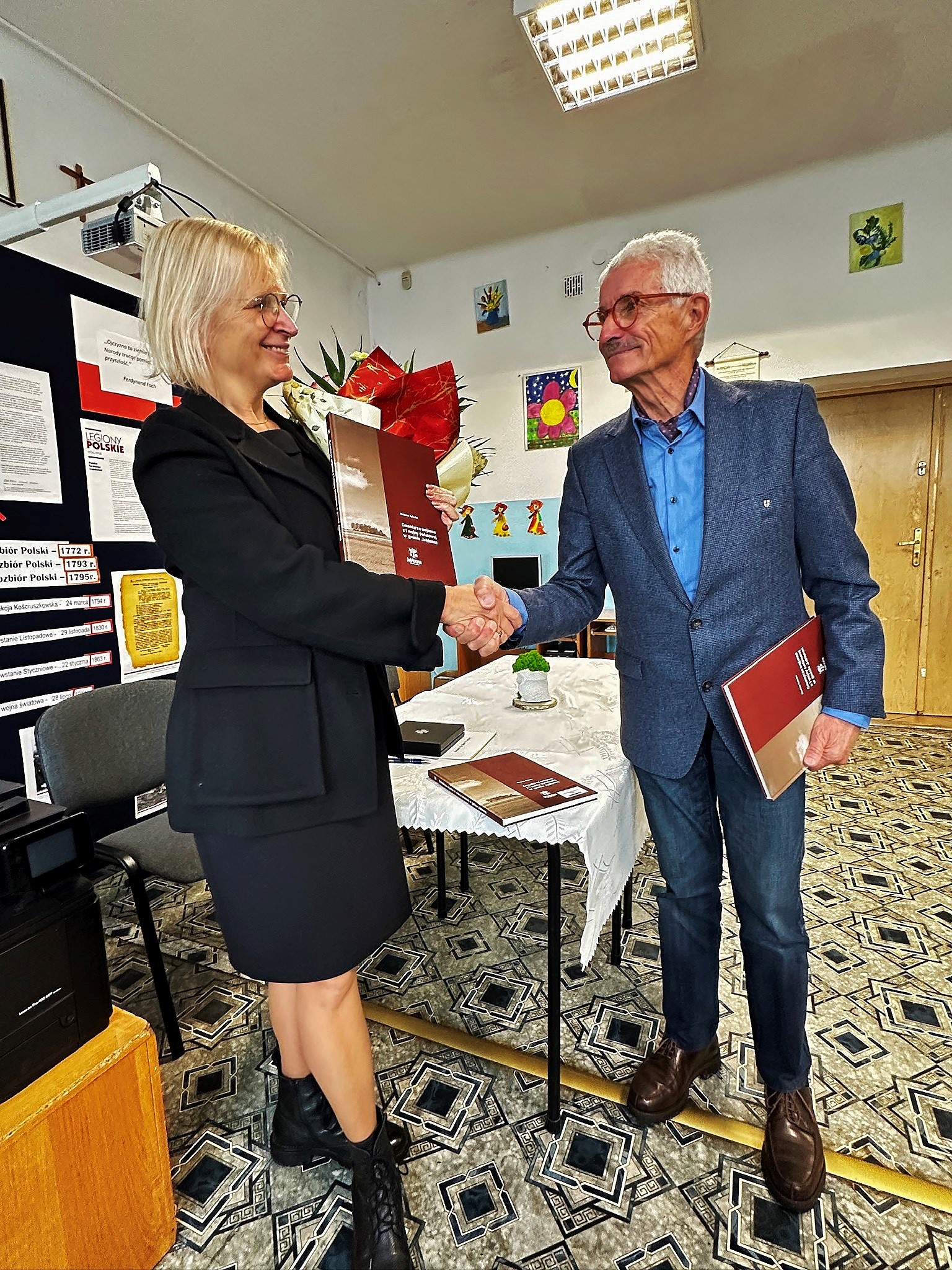 Landesgeschäftsführer Oberst i.R. Dieter Allesch erhält von der Autorin Marzena Gałecka das druckfrische Buch "Soldatenfriedhöfe aus dem Ersten Weltkrieg in der Gemeinde Jabłonna"